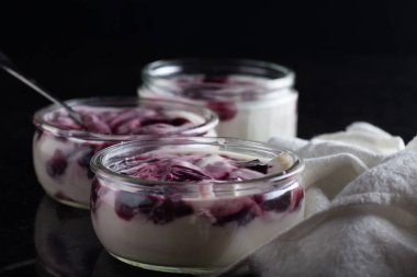 Yoğurt karanlık mermer arka plan üzerinde karışım cam kase meyve ile. Doğal ve sağlıklı meyve, diyet, gurme tatlı granola kahvaltı için. Tatlı yoğurt portre