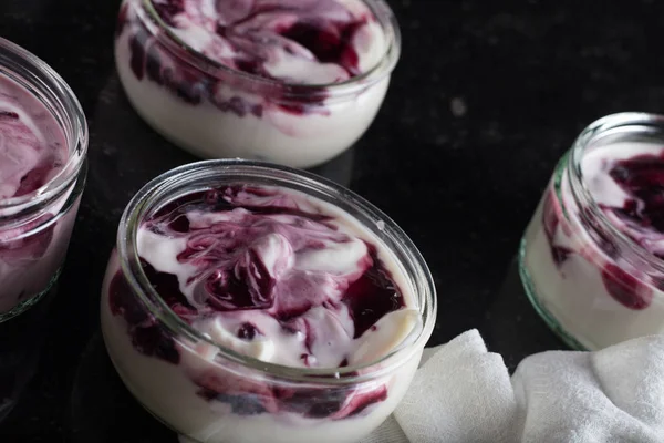 Yoğurt karanlık mermer arka plan üzerinde karışım cam kase meyve ile. Doğal ve sağlıklı meyve, diyet, gurme tatlı granola kahvaltı için. Tatlı yoğurt portre