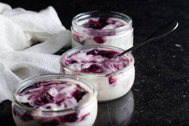 Yoğurt karanlık mermer arka plan üzerinde karışım cam kase meyve ile. Doğal ve sağlıklı meyve, diyet, gurme tatlı granola kahvaltı için. Tatlı yoğurt portre