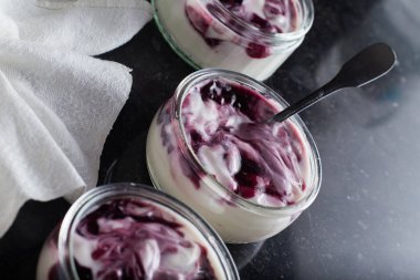 Yoğurt karanlık mermer arka plan üzerinde karışım cam kase meyve ile. Doğal ve sağlıklı meyve, diyet, gurme tatlı granola kahvaltı için. Tatlı yoğurt portre