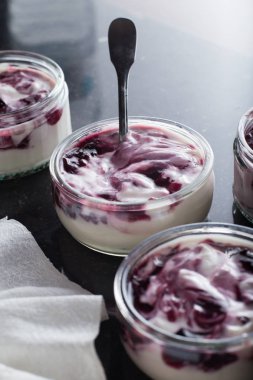 Yoğurt karanlık mermer arka plan üzerinde karışım cam kase meyve ile. Doğal ve sağlıklı meyve, diyet, gurme tatlı granola kahvaltı için. Tatlı yoğurt portre