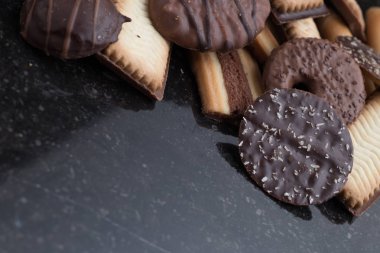 Siyah arka plan üzerine çeşitli kurabiyeler. Kahvaltı, Kahvaltı ve öğle yemeği için lezzetli sabah aperatifler. Apetisant, tatlı ve fast food