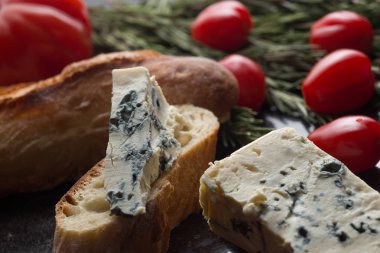 Mavi peynir ile Fransız baget, domates ve siyah mermer masa üzerinde otlar. Fransa ve İtalya geleneksel aperatifler