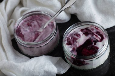 Yoğurt karanlık mermer arka plan üzerinde karışım cam kase meyve ile. Doğal ve sağlıklı meyve, diyet, gurme tatlı granola kahvaltı için. Tatlı yoğurt portre