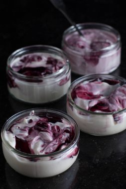 Yoğurt karanlık mermer arka plan üzerinde karışım cam kase meyve ile. Doğal ve sağlıklı meyve, diyet, gurme tatlı granola kahvaltı için. Tatlı yoğurt portre