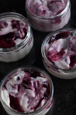 Yoğurt karanlık mermer arka plan üzerinde karışım cam kase meyve ile. Doğal ve sağlıklı meyve, diyet, gurme tatlı granola kahvaltı için. Tatlı yoğurt portre