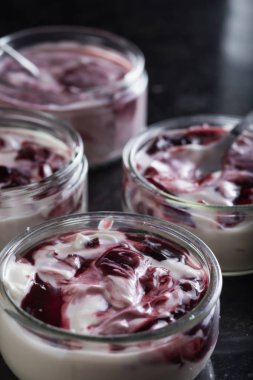 Yoğurt karanlık mermer arka plan üzerinde karışım cam kase meyve ile. Doğal ve sağlıklı meyve, diyet, gurme tatlı granola kahvaltı için. Tatlı yoğurt portre