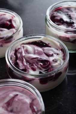 Yoğurt karanlık mermer arka plan üzerinde karışım cam kase meyve ile. Doğal ve sağlıklı meyve, diyet, gurme tatlı granola kahvaltı için. Tatlı yoğurt portre