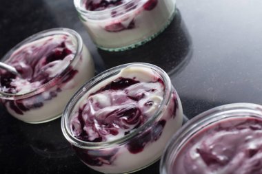 Yoğurt karanlık mermer arka plan üzerinde karışım cam kase meyve ile. Doğal ve sağlıklı meyve, diyet, gurme tatlı granola kahvaltı için. Tatlı yoğurt portre