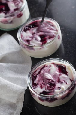 Yoğurt karanlık mermer arka plan üzerinde karışım cam kase meyve ile. Doğal ve sağlıklı meyve, diyet, gurme tatlı granola kahvaltı için. Tatlı yoğurt portre