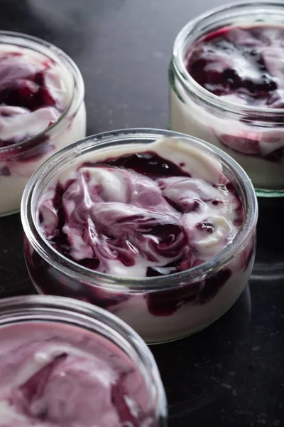 Yoğurt karanlık mermer arka plan üzerinde karışım cam kase meyve ile. Doğal ve sağlıklı meyve, diyet, gurme tatlı granola kahvaltı için. Tatlı yoğurt portre