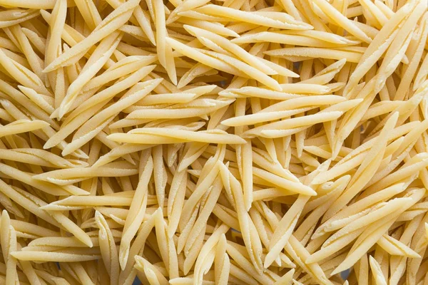 Pasta fundo close-up cru. Delicioso ingrediente seco não cozido para pratos tradicionais da cozinha italiana. Formas de variedade texturizadas. Vista superior. Espaço de cópia — Fotografia de Stock