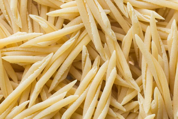 Pasta fundo close-up cru. Delicioso ingrediente seco não cozido para pratos tradicionais da cozinha italiana. Formas de variedade texturizadas. Vista superior. Espaço de cópia — Fotografia de Stock