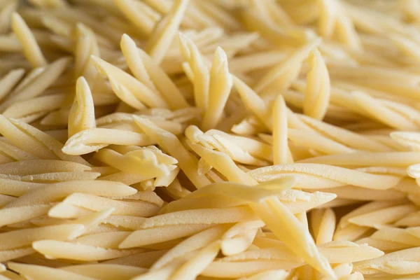 Pasta fundo close-up cru. Delicioso ingrediente seco não cozido para pratos tradicionais da cozinha italiana. Formas de variedade texturizadas. Vista superior. Espaço de cópia — Fotografia de Stock