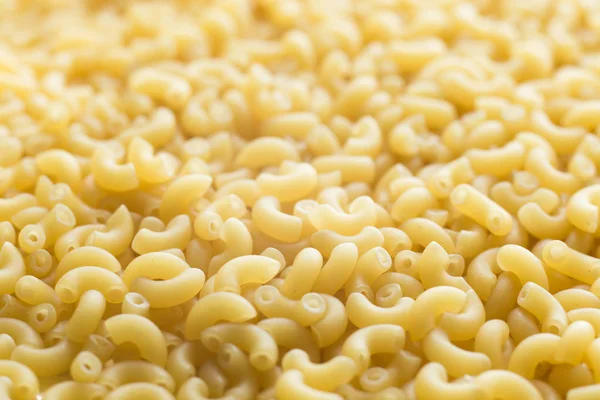 Pasta fundo close-up cru. Delicioso ingrediente seco não cozido para pratos tradicionais da cozinha italiana. Formas de variedade texturizadas. Vista superior. Espaço de cópia — Fotografia de Stock