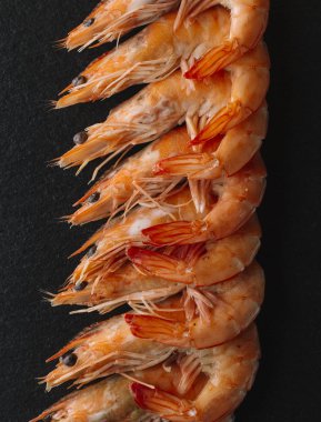 Siyah arka plan üzerine karides. Lezzetli deniz ürünleri meze haşlama veya ızgara baharatlar ile servis. Yakın çekim. Üstten Görünüm