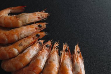 Siyah arka plan üzerine karides. Lezzetli deniz ürünleri meze haşlama veya ızgara baharatlar ile servis. Yakın çekim. Üstten Görünüm