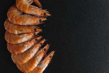 Siyah arka plan üzerine karides. Lezzetli deniz ürünleri meze haşlama veya ızgara baharatlar ile servis. Yakın çekim. Üstten Görünüm