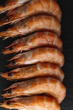 Siyah arka plan üzerine karides. Lezzetli deniz ürünleri meze haşlama veya ızgara baharatlar ile servis. Yakın çekim. Üstten Görünüm