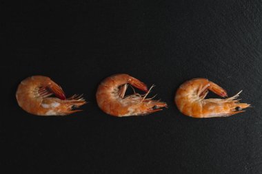 Siyah arka plan üzerine karides. Lezzetli deniz ürünleri meze haşlama veya ızgara baharatlar ile servis. Yakın çekim. Üstten Görünüm