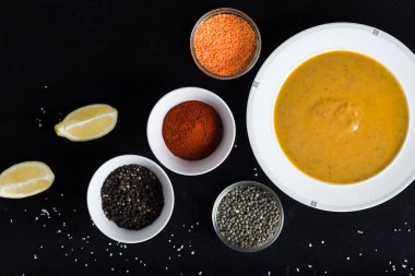 Krem çeşitli mercimek çorbası. Sarı ve yeşil lens, baharat olarak çiğ yemek ve limon siyah backgraund üzerinde. Sağlıklı, lezzetli, lezzetli, vejetaryen yemek. Üstten Görünüm, kopya alanı