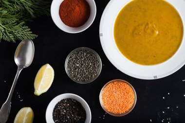 Krem çeşitli mercimek çorbası. Sarı ve yeşil lens, baharat olarak çiğ yemek ve limon siyah backgraund üzerinde. Sağlıklı, lezzetli, lezzetli, vejetaryen yemek. Üstten Görünüm, kopya alanı