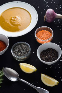 Krem çeşitli mercimek çorbası. Sarı ve yeşil lens, baharat olarak çiğ yemek ve limon siyah backgraund üzerinde. Sağlıklı, lezzetli, lezzetli, vejetaryen yemek. Üstten Görünüm, kopya alanı
