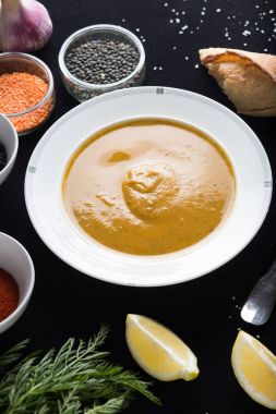 Krem çeşitli mercimek çorbası. Sarı ve yeşil lens, baharat olarak çiğ yemek ve limon siyah backgraund üzerinde. Sağlıklı, lezzetli, lezzetli, vejetaryen yemek. Üstten Görünüm, kopya alanı