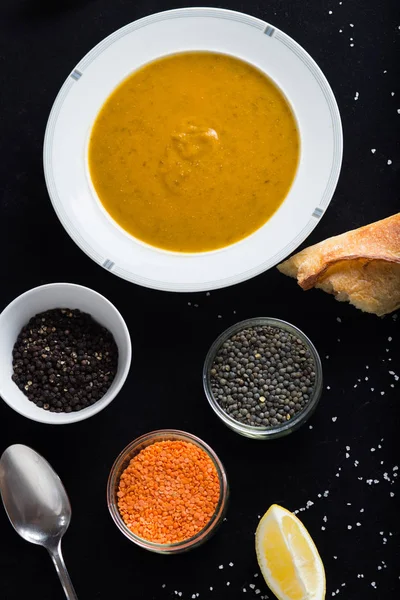 Krem çeşitli mercimek çorbası. Sarı ve yeşil lens, baharat olarak çiğ yemek ve limon siyah backgraund üzerinde. Sağlıklı, lezzetli, lezzetli, vejetaryen yemek. Üstten Görünüm, kopya alanı