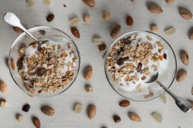 Granola yoğurt, fındık ve açık renkli cam kase meyve ile. Kahvaltı için lezzetli, sağlıklı tatlı tatlı. Mısır gevreği, müsli. Kopya alanı, portre