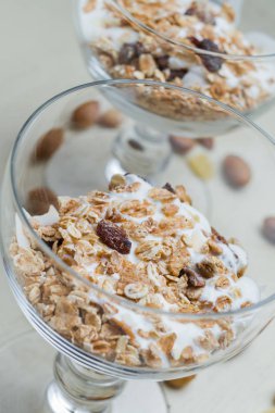 Granola yoğurt, fındık ve açık renkli cam kase meyve ile. Kahvaltı için lezzetli, sağlıklı tatlı tatlı. Mısır gevreği, müsli. Kopya alanı, portre