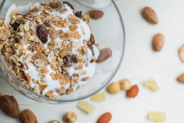 Granola yoğurt, fındık ve açık renkli cam kase meyve ile. Kahvaltı için lezzetli, sağlıklı tatlı tatlı. Mısır gevreği, müsli. Kopya alanı, portre