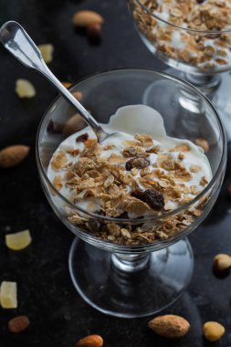 Granola yoğurt, fındık ve koyu arka plan üzerinde cam kase meyve ile. Kahvaltı için lezzetli, sağlıklı tatlı tatlı. Mısır gevreği, müsli. Kopya alanı, portre