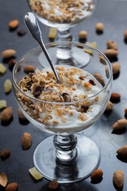 Granola yoğurt, fındık ve koyu arka plan üzerinde cam kase meyve ile. Kahvaltı için lezzetli, sağlıklı tatlı tatlı. Mısır gevreği, müsli. Kopya alanı, portre