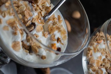 Granola yoğurt, fındık ve koyu arka plan üzerinde cam kase meyve ile. Kahvaltı için lezzetli, sağlıklı tatlı tatlı. Mısır gevreği, müsli. Kopya alanı, portre