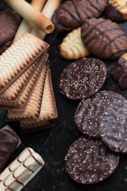 Siyah arka plan üzerine çeşitli kurabiyeler. Kahvaltı, Kahvaltı ve öğle yemeği için lezzetli sabah aperatifler. Apetisant, tatlı ve fast food