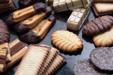 Siyah arka plan üzerine çeşitli kurabiyeler. Kahvaltı, Kahvaltı ve öğle yemeği için lezzetli sabah aperatifler. Apetisant, tatlı ve fast food