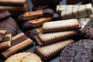 Siyah arka plan üzerine çeşitli kurabiyeler. Kahvaltı, Kahvaltı ve öğle yemeği için lezzetli sabah aperatifler. Apetisant, tatlı ve fast food