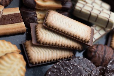 Siyah arka plan üzerine çeşitli kurabiyeler. Kahvaltı, Kahvaltı ve öğle yemeği için lezzetli sabah aperatifler. Apetisant, tatlı ve fast food