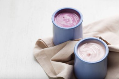 Ahşap ligth zemin üzerine seramik kase yoğurt ürün yelpazesine sahip. Doğal ve sağlıklı meyve, diyet, gurme tatlı granola kahvaltı için. Tatlı yoğurt portre