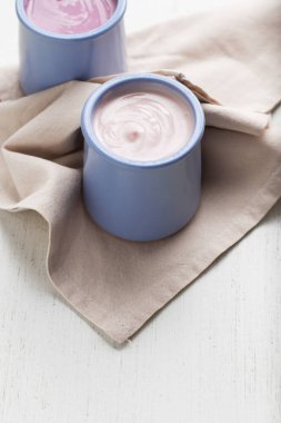 Ahşap ligth zemin üzerine seramik kase yoğurt ürün yelpazesine sahip. Doğal ve sağlıklı meyve, diyet, gurme tatlı granola kahvaltı için. Tatlı yoğurt portre