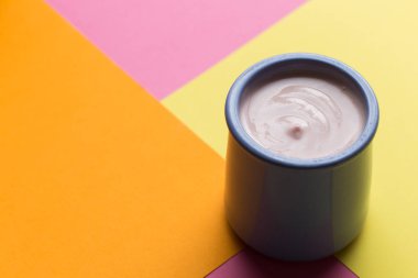Renkli arka plan üzerinde seramik kase yoğurt ürün yelpazesine sahip. Doğal ve sağlıklı meyve, diyet, gurme tatlı granola kahvaltı için. Tatlı yoğurt portre