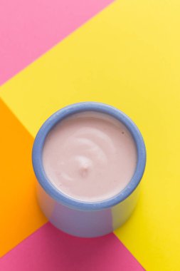 Renkli arka plan üzerinde seramik kase yoğurt ürün yelpazesine sahip. Doğal ve sağlıklı meyve, diyet, gurme tatlı granola kahvaltı için. Tatlı yoğurt portre