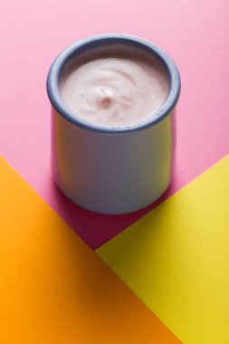 Renkli arka plan üzerinde seramik kase yoğurt ürün yelpazesine sahip. Doğal ve sağlıklı meyve, diyet, gurme tatlı granola kahvaltı için. Tatlı yoğurt portre