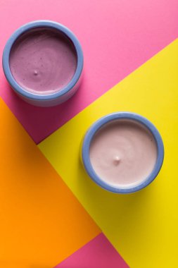 Renkli arka plan üzerinde seramik kase yoğurt ürün yelpazesine sahip. Doğal ve sağlıklı meyve, diyet, gurme tatlı granola kahvaltı için. Tatlı yoğurt portre