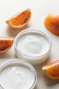 Yoğurt veya cam ligth arka plan üzerinde kozmetik krem ürün yelpazesine sahip. Doğal, sağlıklı, gurme tatlı granola kahvaltı için. Tatlı yoğurt closeup kopya alanı ile