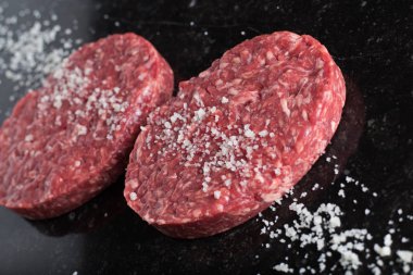 Burger, ızgara, Barbekü, Barbekü için et. Taze, lezzetli pişmemiş baharatlı sığır eti hamburger kopya alanı closeup ile koyu arka plan üzerinde için