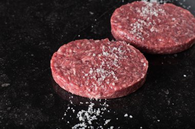 Burger, ızgara, Barbekü, Barbekü için et. Taze, lezzetli pişmemiş baharatlı sığır eti hamburger kopya alanı closeup ile koyu arka plan üzerinde için