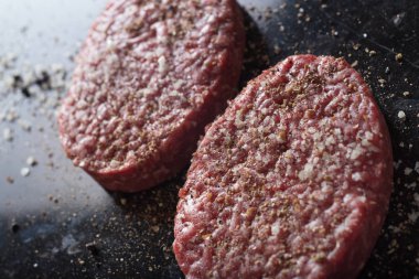 Burger, ızgara, Barbekü, Barbekü için et. Taze, lezzetli pişmemiş baharatlı sığır eti hamburger kopya alanı closeup ile koyu arka plan üzerinde için