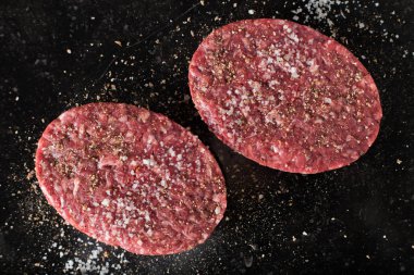 Burger, ızgara, Barbekü, Barbekü için et. Taze, lezzetli pişmemiş baharatlı sığır eti hamburger kopya alanı closeup ile koyu arka plan üzerinde için